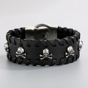 Detail view of black leather punk bracelet with five stainless steel skull ornaments