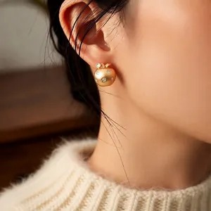 Minimalist 18K gold-plated apple stud earring with star zircon inlay worn by model