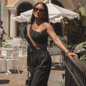 Women's chic black one-shoulder cutout bodysuit paired with high-waist wide-leg pants