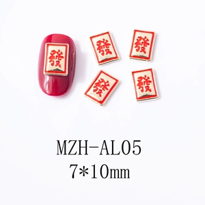 Close-up of red and gold Mahjong charm for festive New Year nail art design