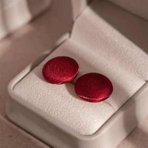 Macro view of vintage Ancora red velvet stud earrings with soft texture and rich shine