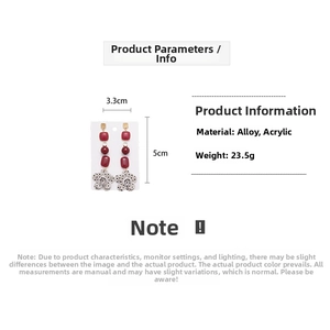 Detail view of red acrylic earrings with floral charms and white polka dot patterns