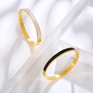 Close-up of gold-plated bangle hinges with black and white enamel inlays on white steps