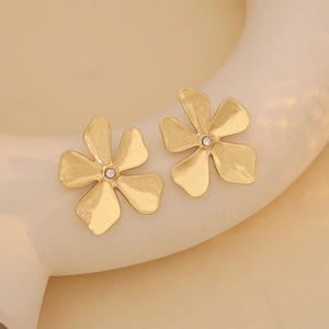Macro view of gold-tone five-petal flower earrings with center rhinestone detail