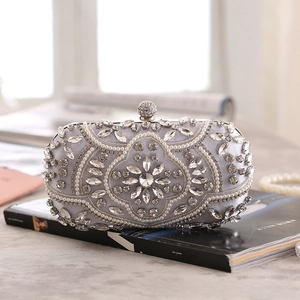 Detail of silver satin evening clutch with hand-set rhinestones and floral pearl patterns