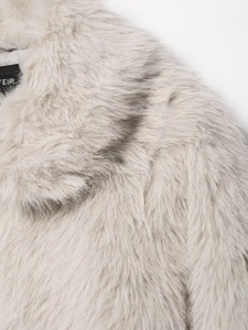 Close-up of the long fluffy faux fur collar and black brand label in light grey
