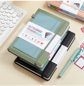Close-up of undated daily planner featuring hour slots, task lists, and elastic band