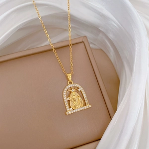 Détail macro du collier en acier titane doré avec pendentif buste de Jésus en zircon