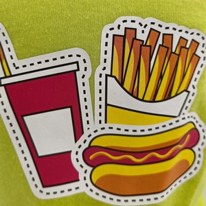 Detailed macro view of PVC fast food patches showing red and yellow fries on green fabric