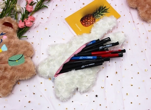 Gros plan d'une trousse en peluche blanche avec doublure rose et fermeture éclair
