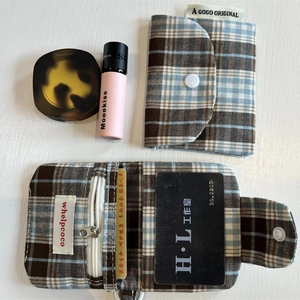 Detail of vintage plaid card holder set with metal zipper and snap button closure