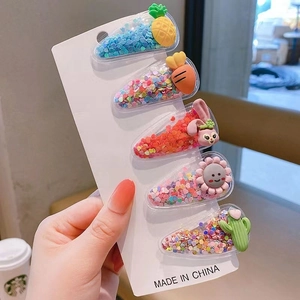 Detail view of five transparent sequin hair clips with cartoon resin charms on card