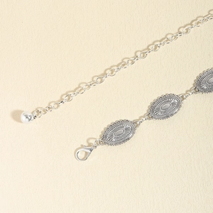 Detail of vintage silver metal waist chain with bohemian oval sunburst carved links