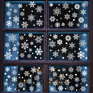 White snowflake window stickers on rustic wooden frames creating a cozy holiday atmosphere