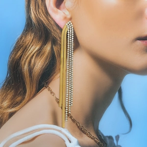 Elegant gold-plated snake chain tassel earrings with sparkling rhinestones on a model