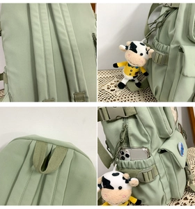 Dettaglio dello zaino verde con spallacci spessi, tasche laterali e ciondolo a mucca