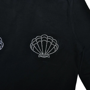 Close-up of sparkling rhinestone seashell pattern on black slim fit long sleeve T-shirt