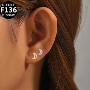 Close-up of crescent moon F136 titanium cartilage stud earring on model's ear