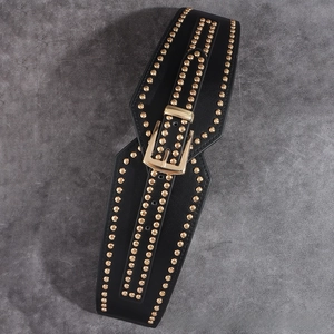 Close-up of black elastic waist belt with gold rivet studs and metallic buckle