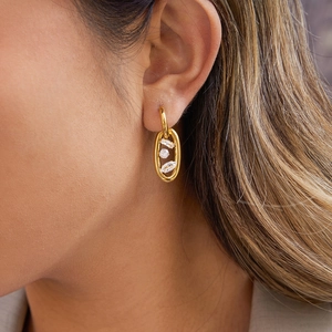 Dettaglio di orecchini in oro 18k con zirconi cubici a taglio tondo, rettangolo e marquise