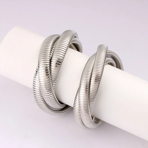 Macro view of three-layer flexible silver steel spring coils wrapped on a white stand