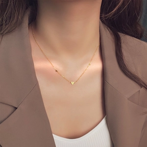Minimalist gold heart pendant necklace for women shown on a model neck in close-up