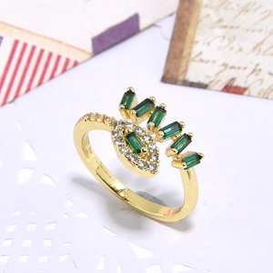 Detailed macro view of gold-plated eye ring with emerald green zircon and crystals
