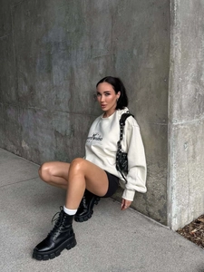 Photo de mode urbaine du sweat blanc à col rond avec motif ours et bottines noires