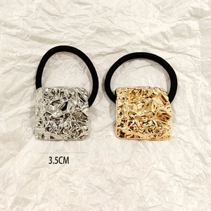 Detail of 3.5cm hollow square metal hair ties in gold and silver with textured finish