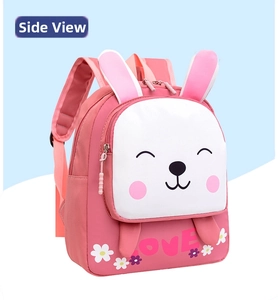 Vista lateral de una linda mochila de dibujos animados de conejo rosa y blanco para niños