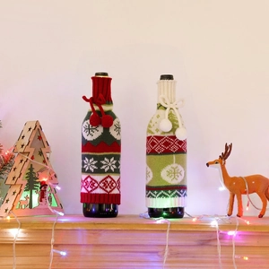 Detail of Christmas knitted wine bottle covers with snowflakes and pom-poms for festive decor
