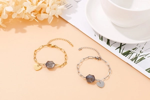 Detailed shot of gold and silver charm bracelets with heart pendants and hexagonal stones