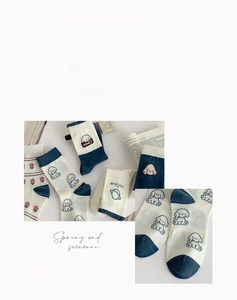 Détail des chaussettes en coton mi-mollet avec rayures bleues et broderie chiot