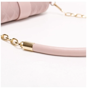 Gros plan détail de la bandoulière en cuir rose avec chaîne dorée, fabrication exquise.