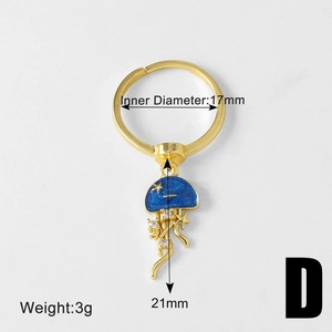 Detailed view of 18k gold ocean jellyfish charm with blue enamel and crystal tentacles