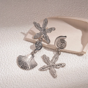 Detailed close-up of vintage silver starfish and seashell charms with textured metal finish
