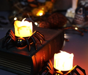 Macro view of LED spider candle lights with warm yellow glow on vintage books decor