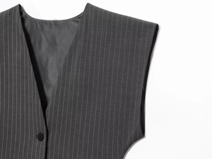 Detail of dark grey pinstripe vest showing the V-neck, button and fabric texture