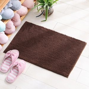 Brown chenille bath mat with non-slip texture on light tile floor in home setting