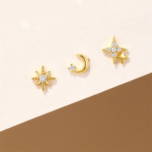 Macro shot of gold star moon stud earrings set with sparkling zircon crystals