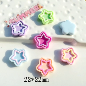 Flat lay of colorful 22mm aurora pentagram plastic pendants for DIY crafts and accessories