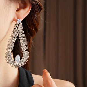 Detailed view of silver mesh teardrop earrings featuring large faceted cubic zirconia