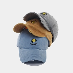 Close-up of distressed baseball caps with sunshine embroidery in blue, yellow and grey