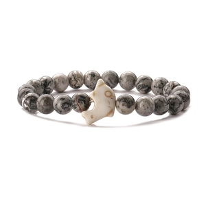 Macro shot of grey stone beaded elastic bracelet with a white dolphin accent bead