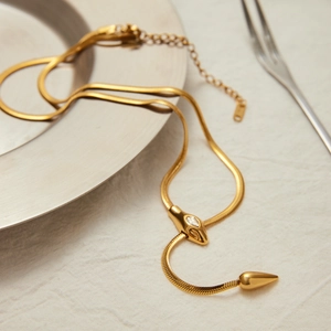 Nahaufnahme der goldenen 18K Edelstahl-Schlangenkette mit Zirkonia-besetztem Schlangenkopf