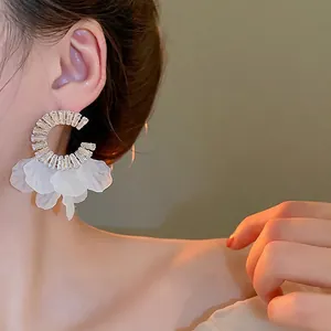 Elegant C-shaped silver earrings with sparkling zircon and delicate white flower petals
