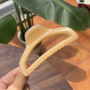 Detail of a large 10cm acetate hair claw clip with beige marble pattern for thick hair