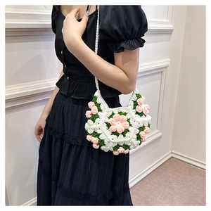 Detailed side view of a handmade 3D puff flower crochet crossbody bag on a model