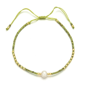 Detail of adjustable olive green braided bracelet with pearl and golden beads accent