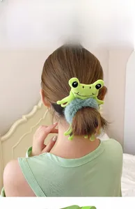 Detail of plush frog hair circle featuring soft green frog with gray-blue fuzzy elastic band